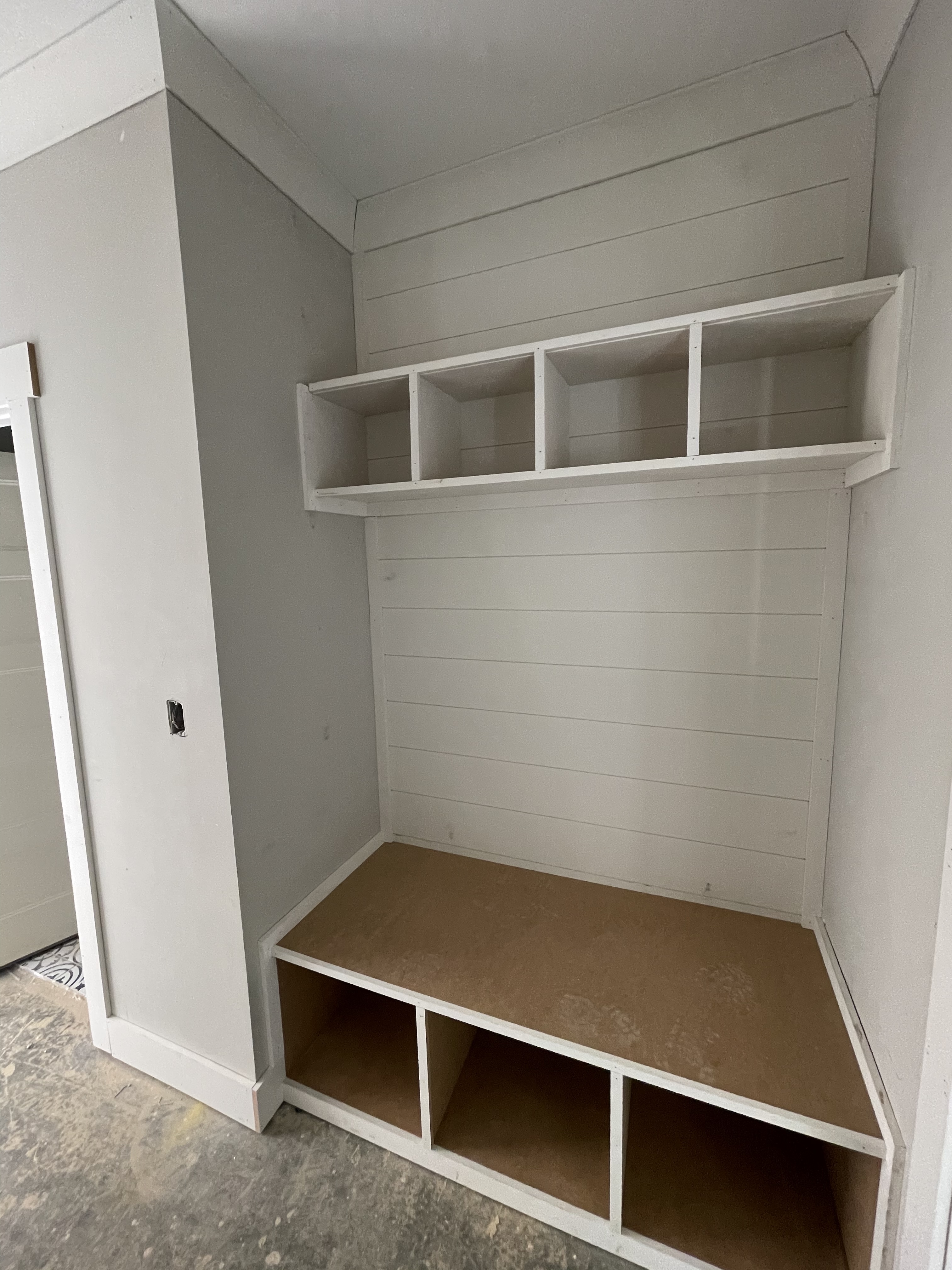 Custom mudroom built-in with shiplap walls and bench seating